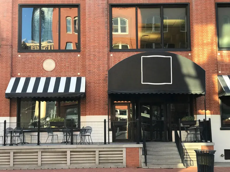 Red-brick commercial premises with awnings over the shopfronts