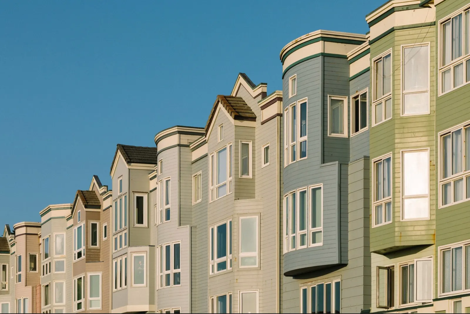 A row of terraced houses against a clear blue sky