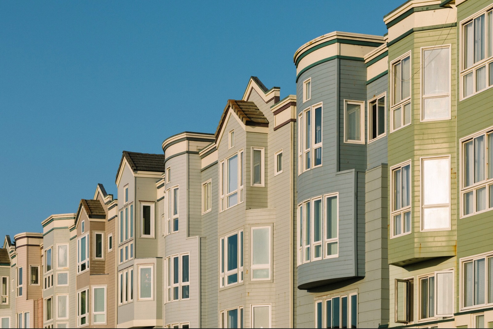 A row of terraced houses against a clear blue sky
